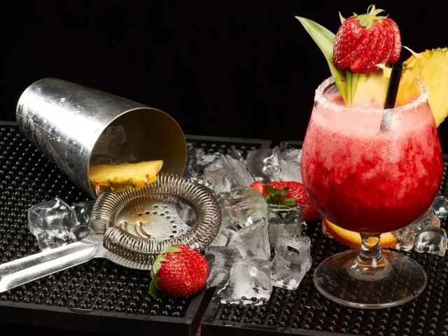 Тропический коктейль в бокале на столе со льдом