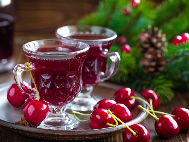 Две чашки вишневого сока со свежими вишнями на столе