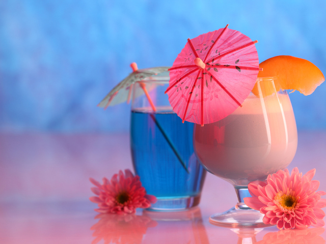 Два бокала с коктейлем на столе с розовыми цветами хризантемы