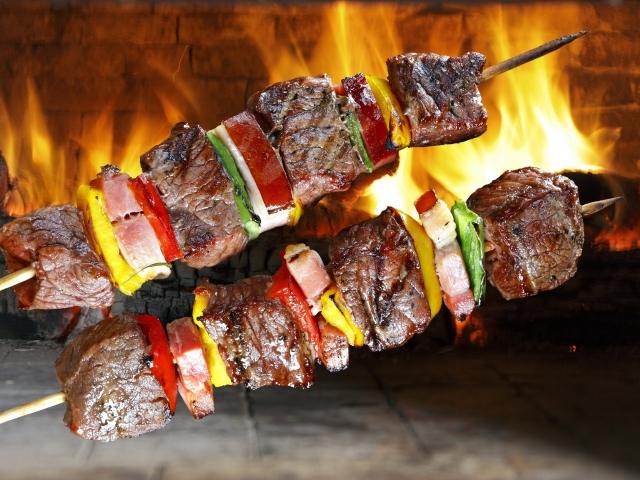 Аппетитный шашлык с овощами на фоне огня