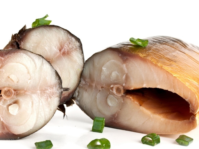 Аппетитная копченая скумбрия с зеленым луком на белом фоне
