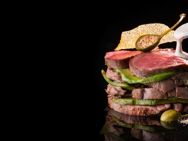 Мясо с авокадо на черном фоне