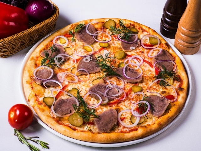 Вкусная пицца с солеными огурцами, языком и луком на столе с овощами