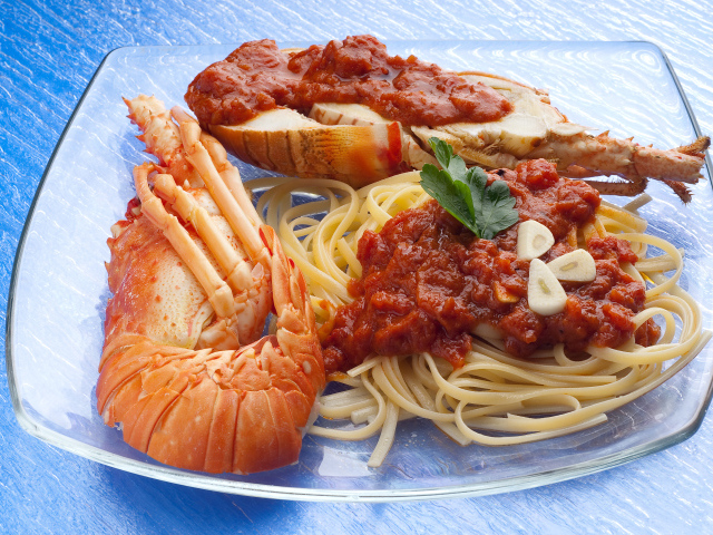 Омар на тарелке со спагетти с соусом