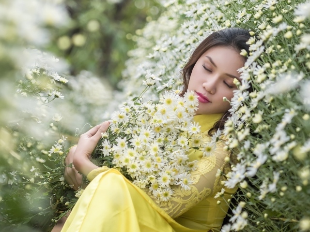 Молодая девушка лежит с букетом белых ромашек