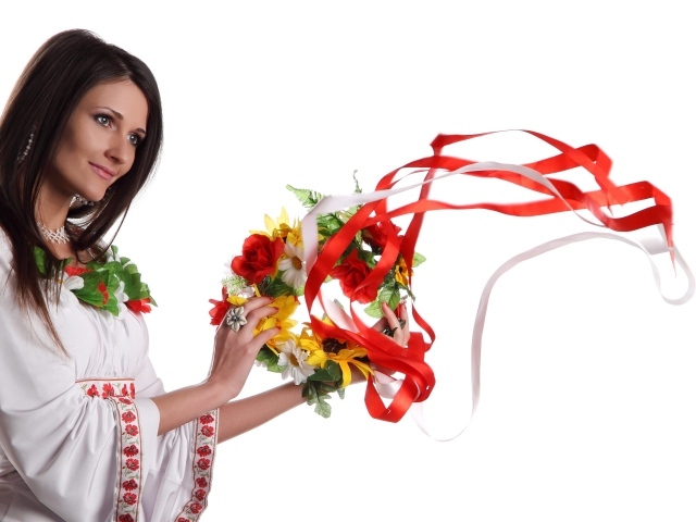 Красивая девушка украинка с венком в руках на белом фоне
