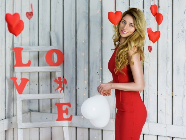 Красивая блондинка в красном платье с шариком