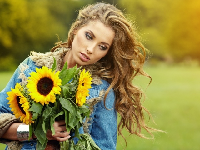Красивая шатенка с букетом подсолнухов в руке