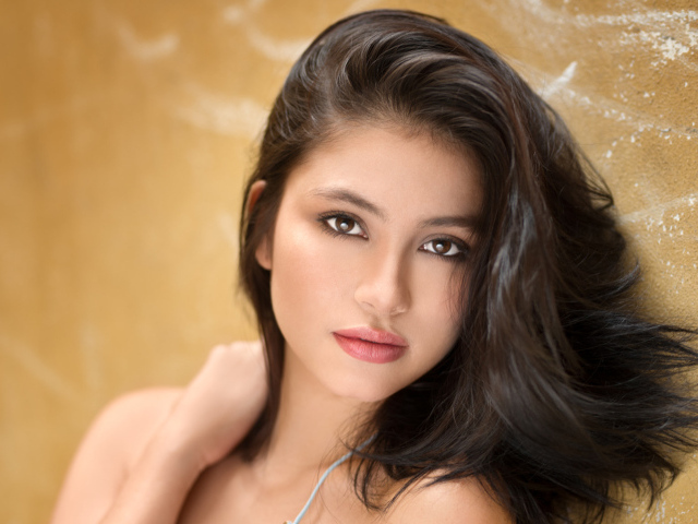 Красивая брюнетка на фоне стены 