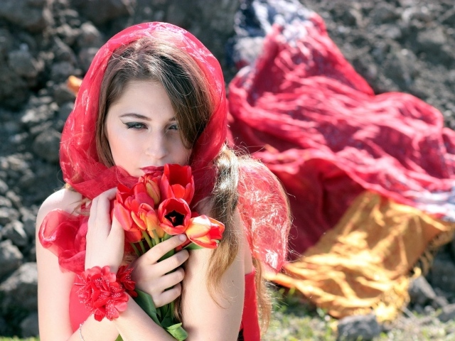 Красивая девушка в красной шали с букетом тюльпанов