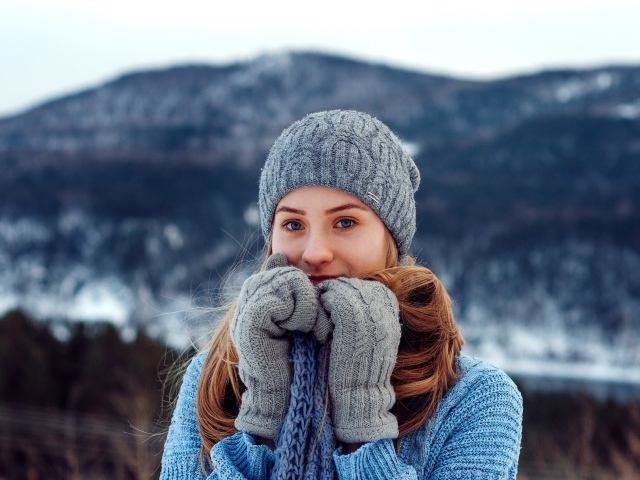 Красивая девушка в теплой шапке и варежках