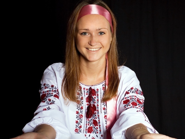 Красивая девушка в вышитой рубашке на черном фоне