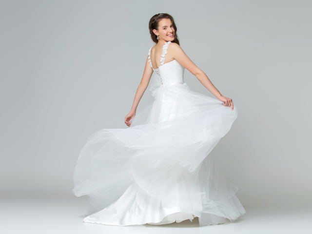 Красивая радостная девушка в белом свадебность платье