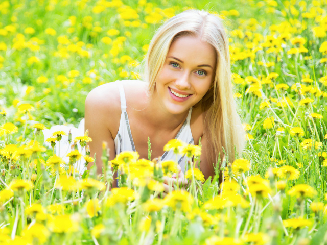 Красивая улыбающаяся блондинка в желтых одуванчиках