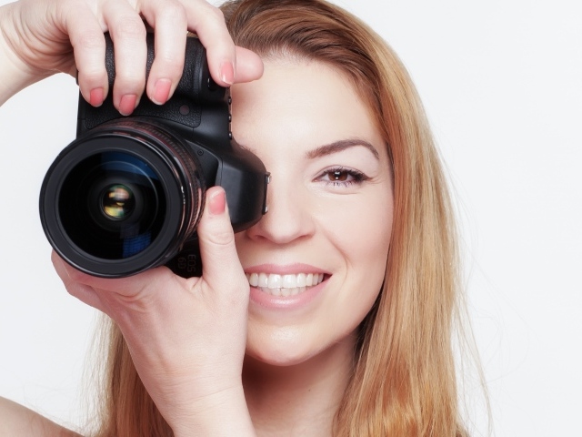 Красивая улыбающаяся девушка с фотоаппаратом