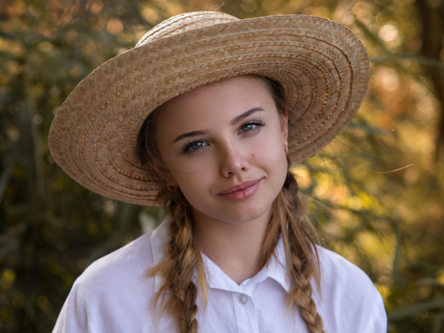 Красивая молодая девушка в соломенной шляпе