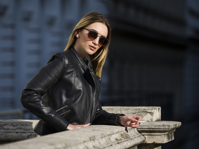 Дерзкая девушка в черной кожаной куртке и очках