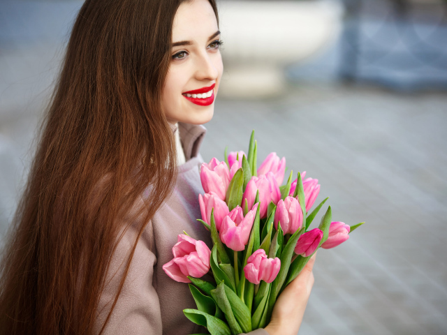 Нежная улыбающаяся девушка шатенка с букетом тюльпанов