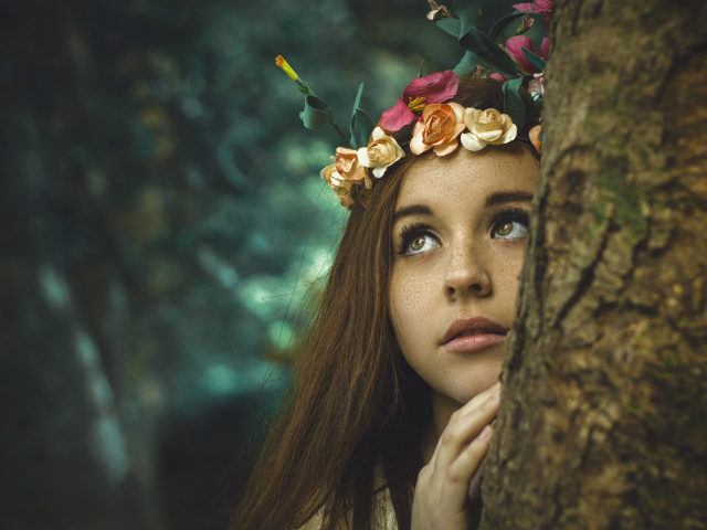 Девушка с венком на голове у дерева 