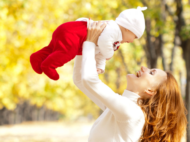 Счастливая девушка с младенцем на руках