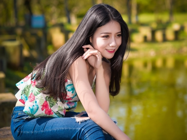 Улыбающаяся красивая девушка азиатка у воды