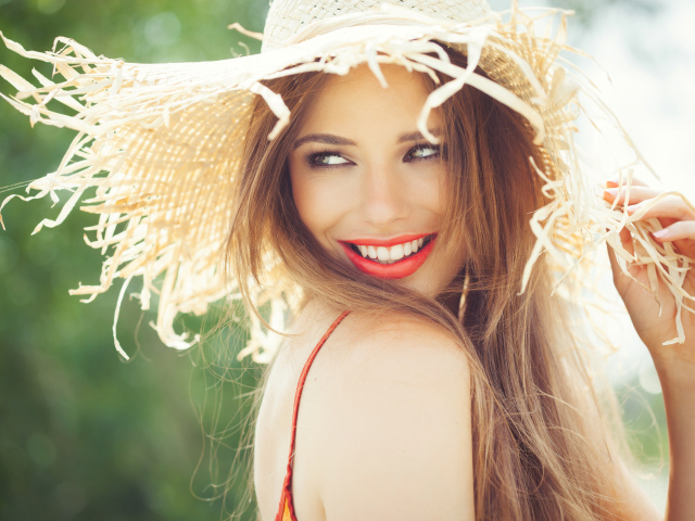 Улыбающаяся девушка в соломенной шляпе летом