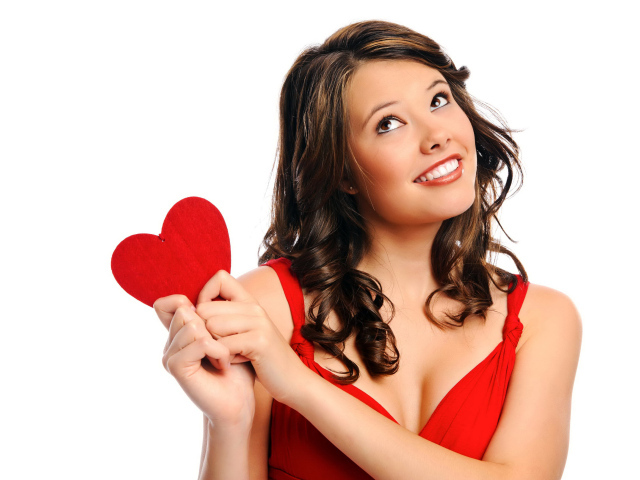 Улыбающаяся девушка с красным сердечком в руках на белом фоне