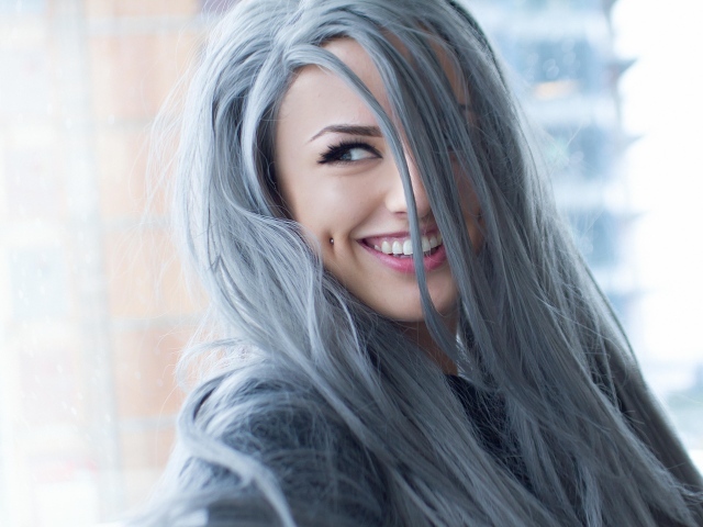 Улыбающаяся эпатажная девушка с пирсингом