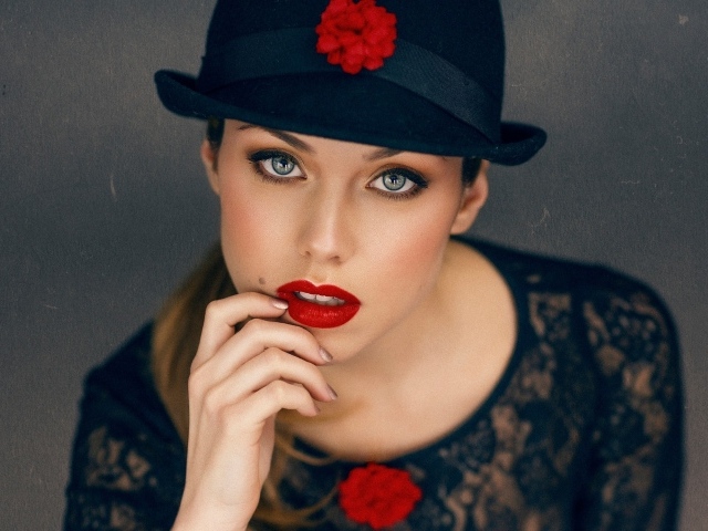 Стильная девушка с ярким макияжем в черной шляпе 