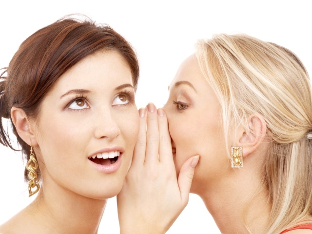 Две подруги делятся секретами на белом фоне 