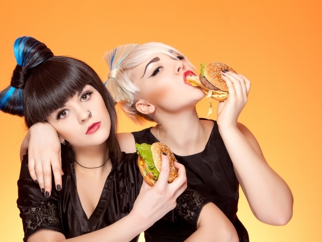 Две девушки с ярким макияжем с гамбургерами