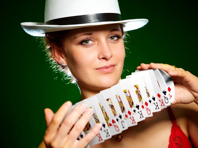Молодая девушка в шляпе с картами в руках