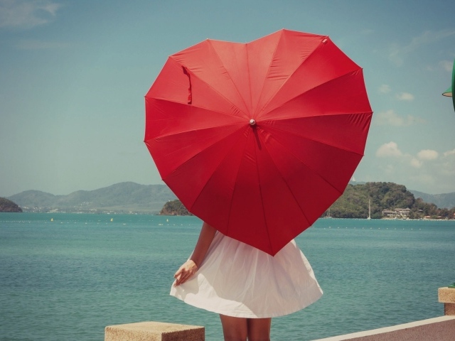 Молодая девушка с красным зонтом в форме сердца