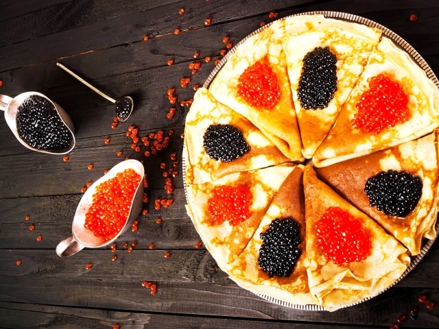 Блины с черной и красной икрой на деревянном столе на Масленицу