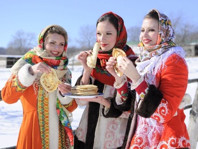 Три молодые красивые девушки с блинами на Масленицу