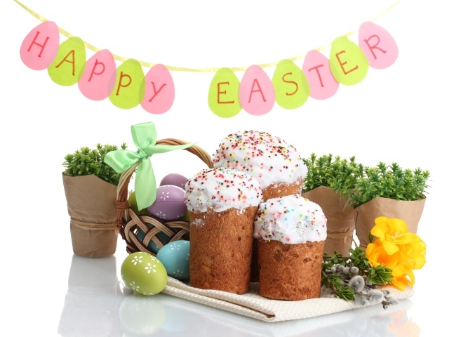 Куличи и крашеные яйца с цветами на белом фоне на праздник Пасха