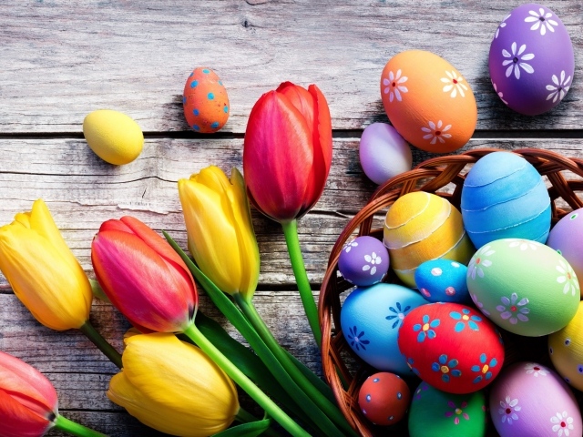 Крашеные яйца на столе с тюльпанами на Пасху