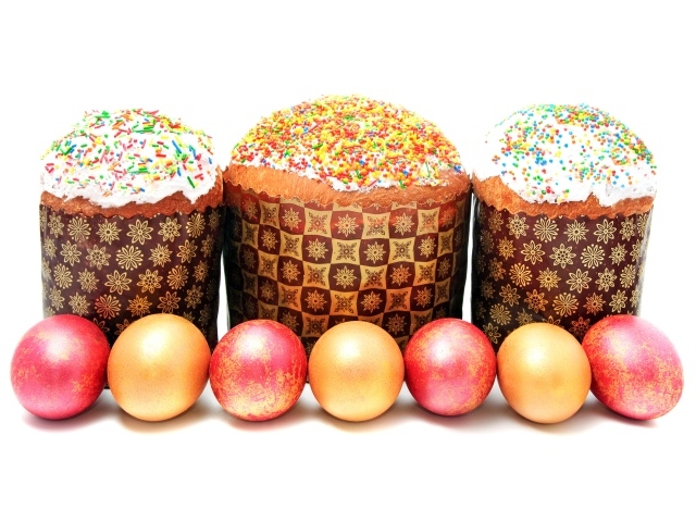 Три пасхальных кулича с крашеными яйцами на белом фоне на праздник Пасха