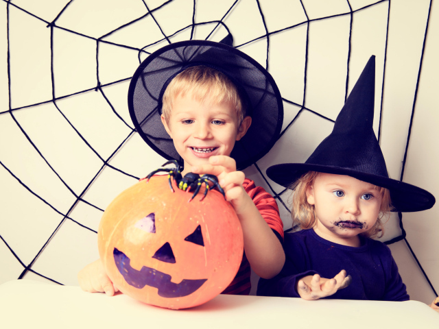 Маленькие мальчик и девочка в костюмах на Хэллоуин