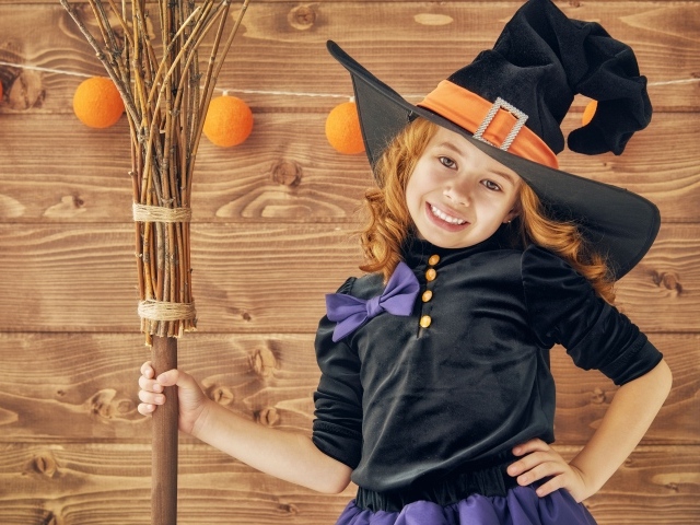Маленькая девочка в костюме ведьмы на праздник Хэллоуин