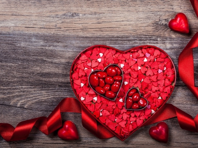 Коробка конфет в форме сердца с красной лентой в подарок