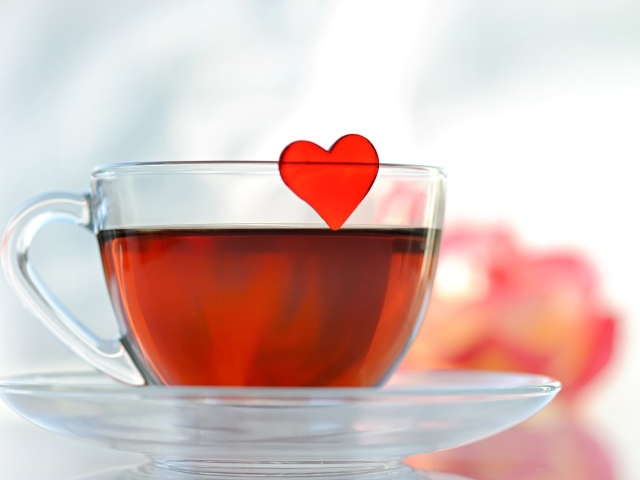 Маленькое красное сердечко в стеклянной чашке с чаем