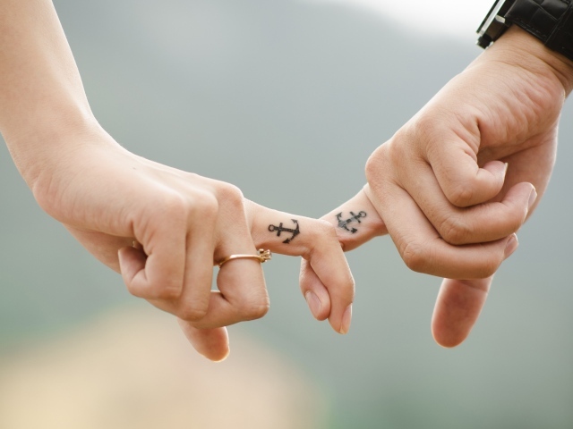 Руки влюбленной пары с татуировками на руках 