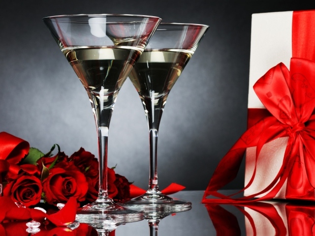 Два бокала с мартини, подарком и красными розами для любимой
