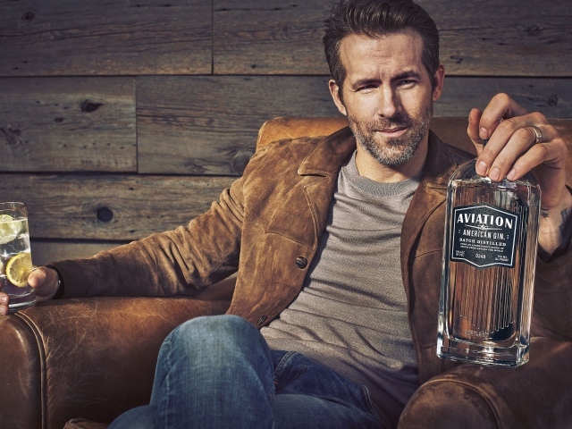 Актер Райан Рейнольдс в кресле с бутылкой в руке