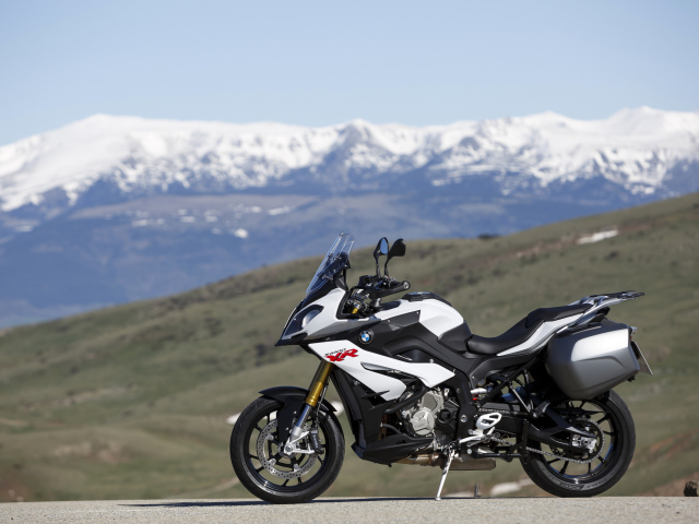 Мотоцикл BMW S1000 XR на фоне заснеженных гор 