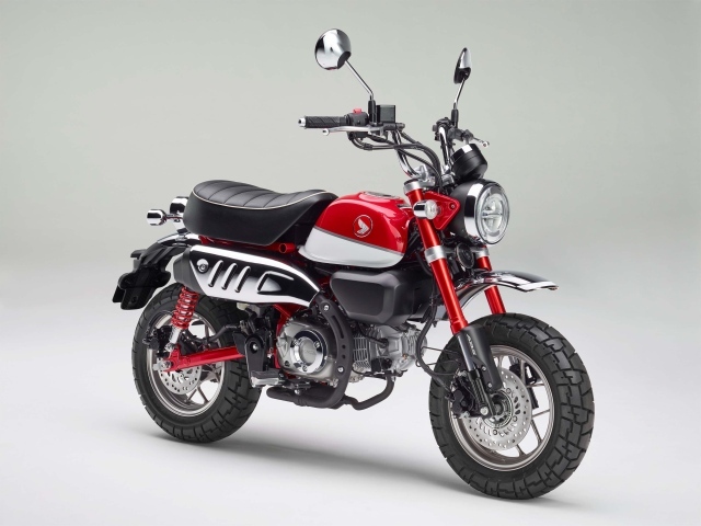 Красный мотоцикл Honda Monkey, 2018 года на сером фоне