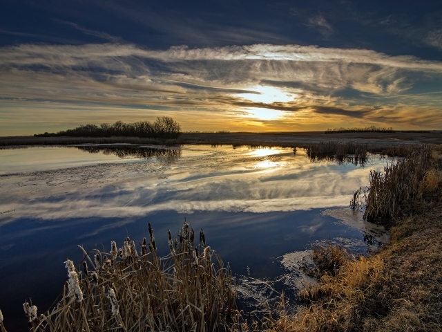 Белые облака отражаются в воде на закате солнца