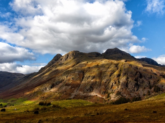 Белые пушистые облака над горой 