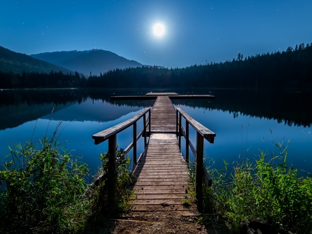 Деревянный мост на озере в полнолуние
